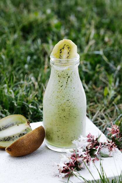 Kiwi milky smoothie in a glass bottle.