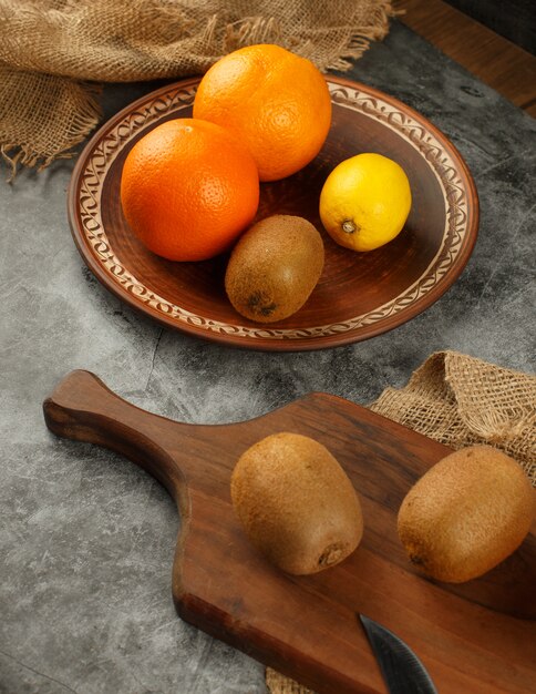 Kiwi, orange and lemon in a rustic background. Top view.