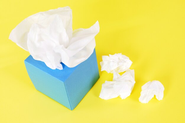 Kleenex style tissues on yellow background