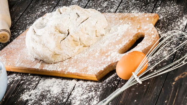 Kneading dough and egg with whisker on the kitchen table