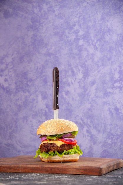 Нож в вкусном мясном бутерброде на деревянной разделочной доске на изолированной поверхности льда со свободным пространством