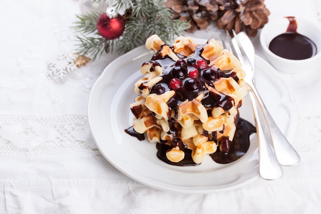 Knife and fork next to some waffles with chocolate