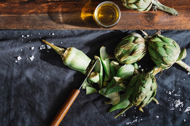 Coltello vicino al taglio di carciofi e olio