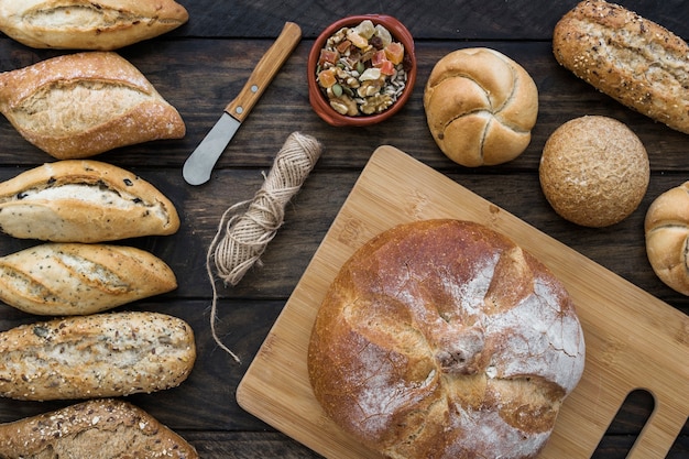 Knife and rope near candied fruits and bread