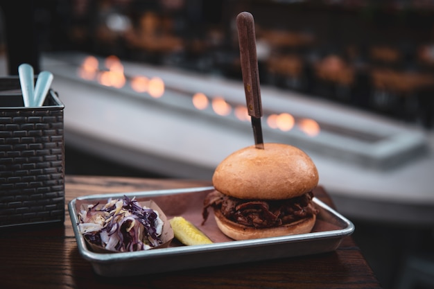 Knife stuck in a burger on a metal tray on the roof