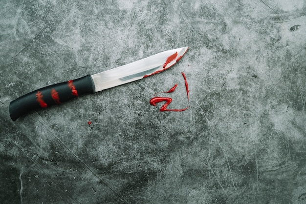 Нож с искусственной кровью на каменном столе