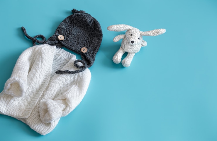 Free Photo knitted baby clothes and accessories on a blue background .