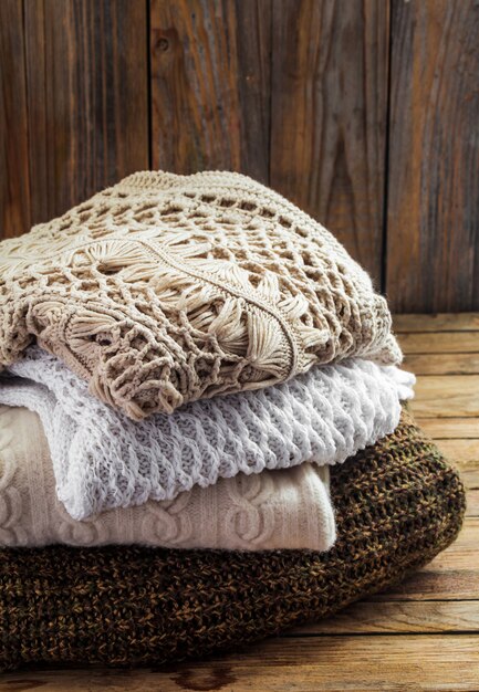 Knitted cosy sweater lying on wooden wall