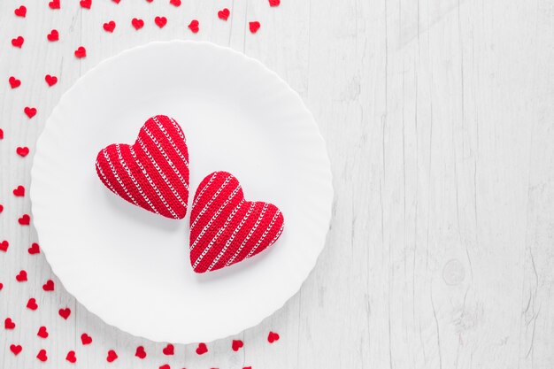Knitted hearts on white plate