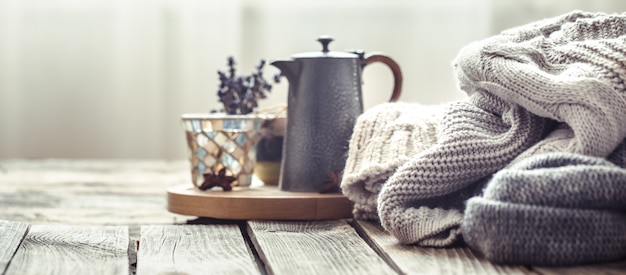 Knitted sweaters on a wooden background in the interior