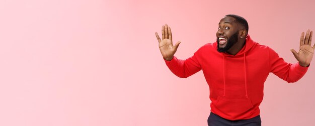 Free photo knock who there charming happy funny black bearded guy bending towards camera raised palms move like