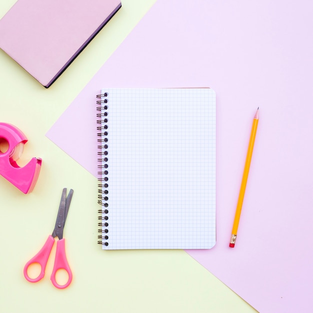 ノート、鉛筆、はさみ、学校に戻ってピンクと黄色の本で机の構成をknolling
