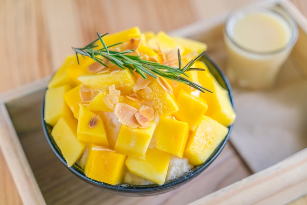 Free photo korean style fresh mango shaved ice on wood table .