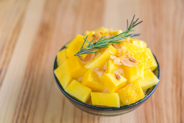 Korean style fresh mango shaved ice on wood table .