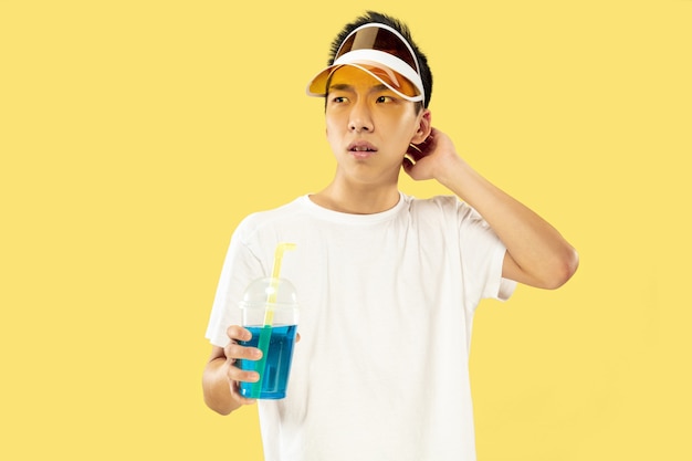 Free photo korean young man's half-length portrait on yellow wall