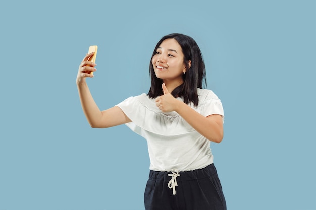 Korean young woman's half-length portrait on blue studio