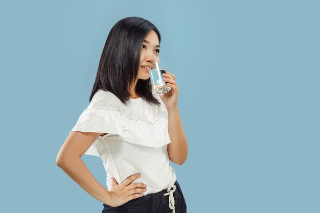 Korean young woman's half-length portrait on blue studio