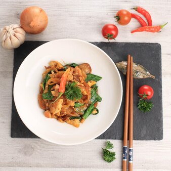 クウェティアウはインドネシアで人気の中華麺で、野菜と鶏肉、シーフード、肉を使って揚げて調理します