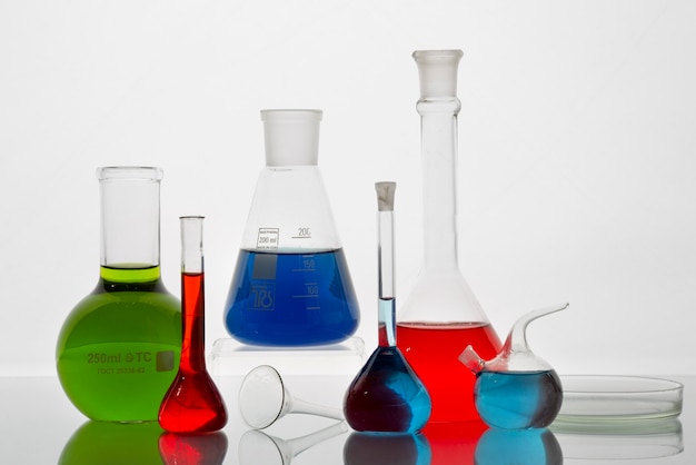 Lab glassware with colored liquids on table