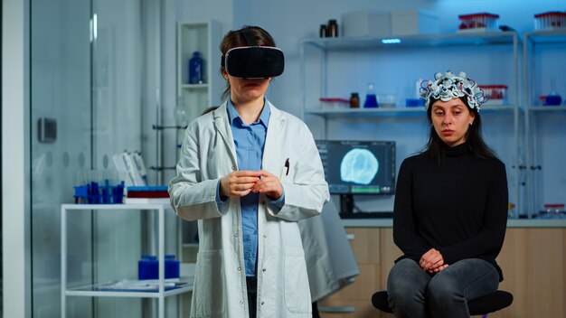 의료 신경학 연구소에서 VR 고글을 사용하여 가상 현실을 경험하는 실험실 의사