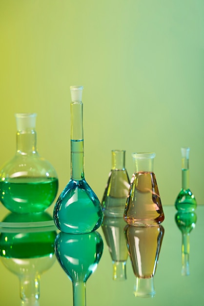 Foto gratuita assortimento di vetreria per laboratorio con sfondo verde