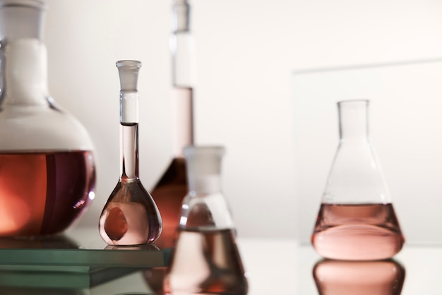 Free photo laboratory glassware with pink liquid arrangement