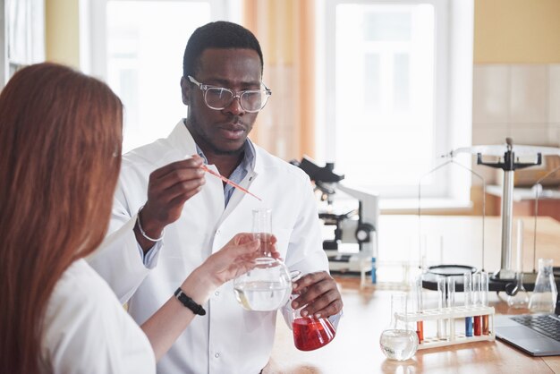 Laboratory laboratories conduct experiments in a chemical laboratory in transparent flasks. Output formulas.