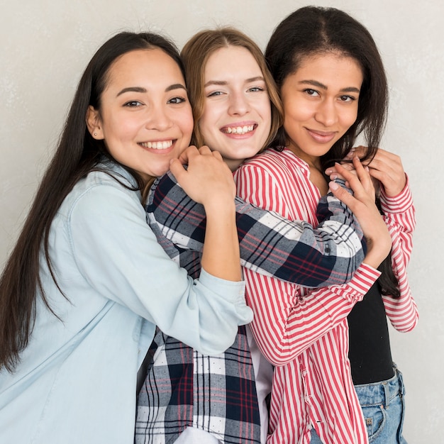 Foto gratuita donne che abbracciano sorridendo e guardando la fotocamera