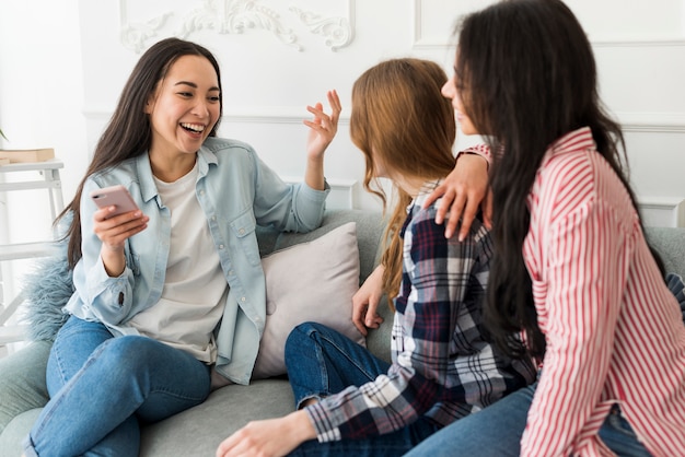 Free photo ladies sitting on sofa and chatting