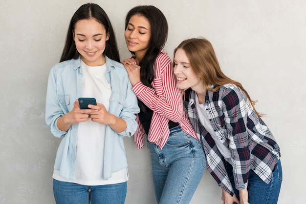 Ladies standing with mobile phone and looking at it