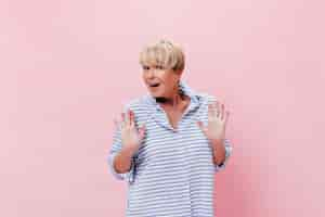 Free photo lady in blue shirt poses on pink background