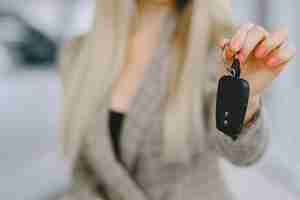 Foto gratuita signora in un salone di automobile. donna che compra l'auto. donna elegante in un abito marrone.