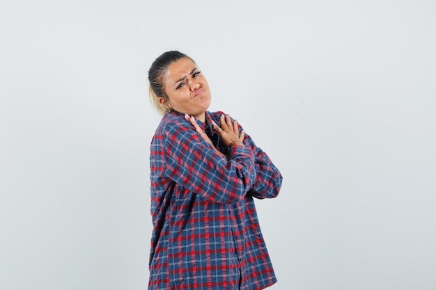 Lady in casual shirt holding crossed arms on chest and looking cute , front view.