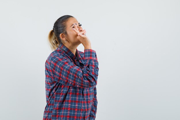 Lady in casual shirt showing tasty gesture and looking delighted , front view.