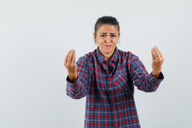 Lady doing Italian gesture, being displeased with dumb question in casual shirt front view.