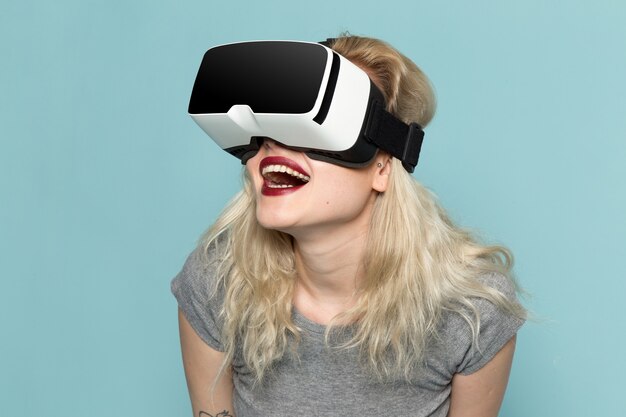 Дама в серой рубашке пробует и играет в позе модели в виртуальной реальности