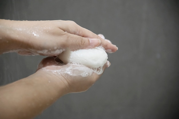 清潔な健康管理の概念 - バスルームの石鹸で女性の手