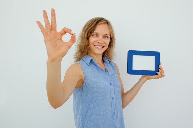 Lady Holding Picture Frame and Showing OK Sign