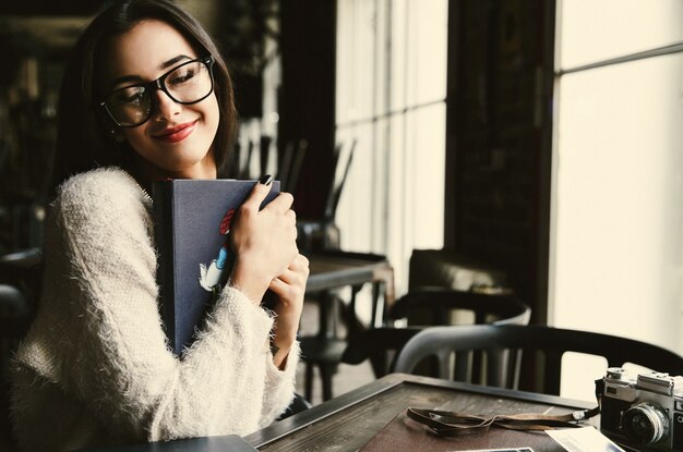 Lady holds old photoalbums tender sitting in the cafe