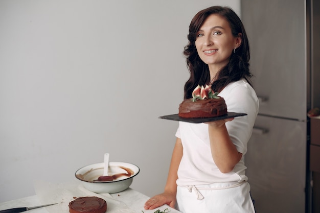 Бесплатное фото Женщина готовит десерт. женщина печет торт. кондитер с шоколадным тортом.