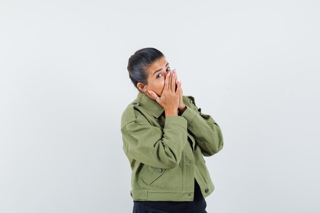 Lady keeping hands on mouth in jacket