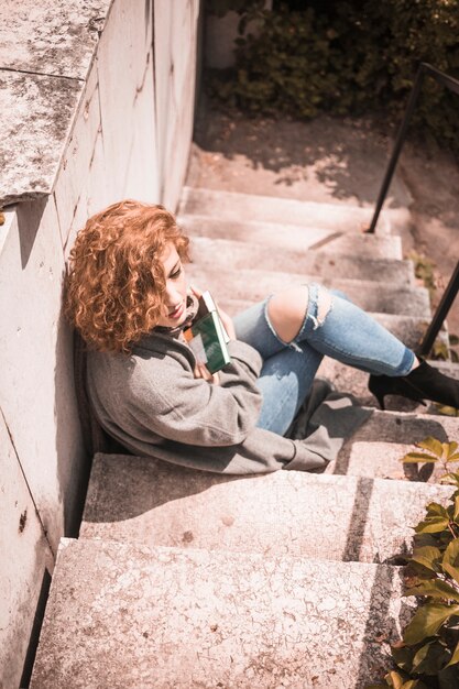 Lady leaning on wall and holding books