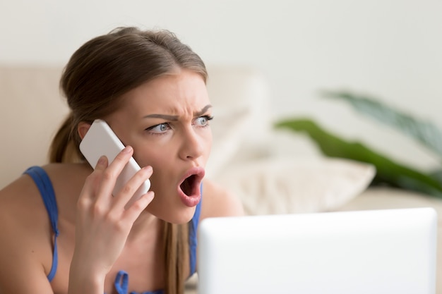 Free photo lady looks shocked when hearing news on cellphone