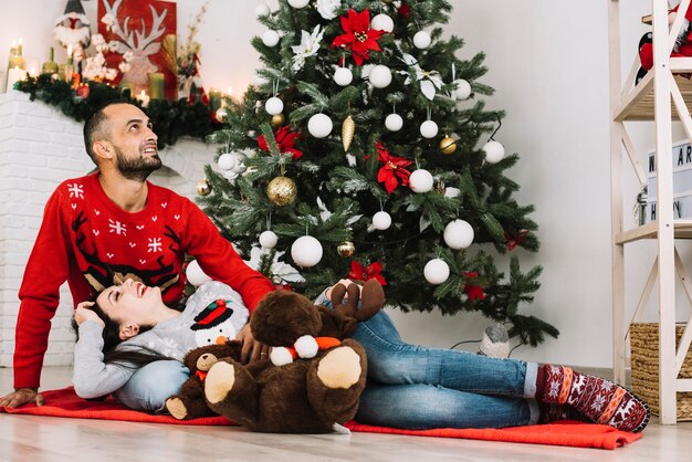 Lady lying on guy near soft toys