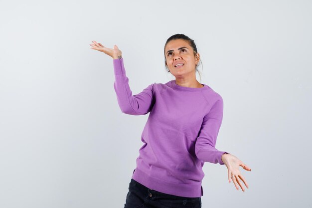 Lady making scales gesture in wool blouse and looking hopeful