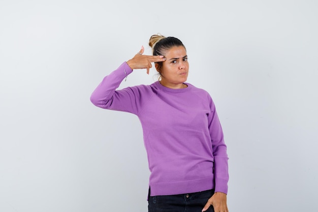 Lady making suicide gesture in wool blouse and looking spiteful