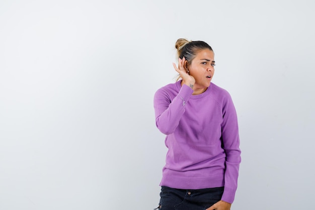 Lady overhearing private conversation in wool blouse and looking curious