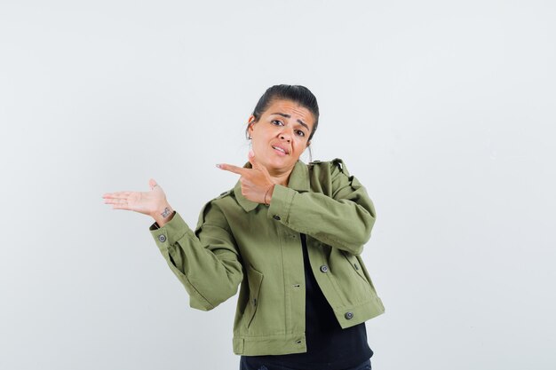 Free photo lady pointing aside by showing something in jacket