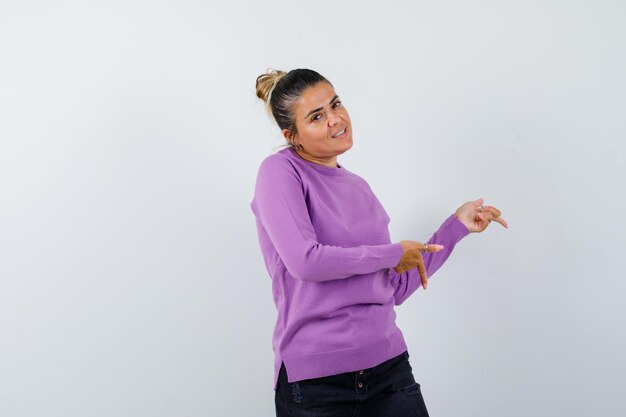 Lady pointing down in wool blouse and looking cheerful