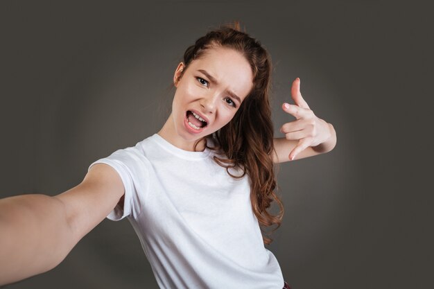 Lady posing while make selfie with rock gesture